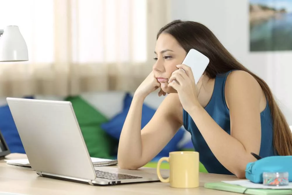 Femme ennuyée qui est en attente téléphonique